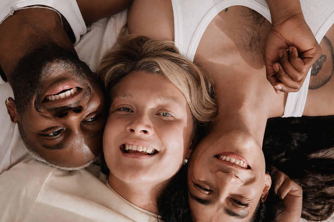 Three people lying close together — inclusive intimacy and connection — The Pleasure Space